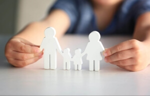 human shaped figurines of a family with a human hand holding each side to symbolize divorce in Missouri.